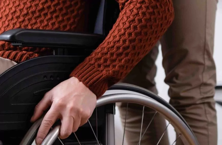 Lähikuvassa ihminen pyörätuolissa ja henkilökohtainen avustaja Jyväskylässä