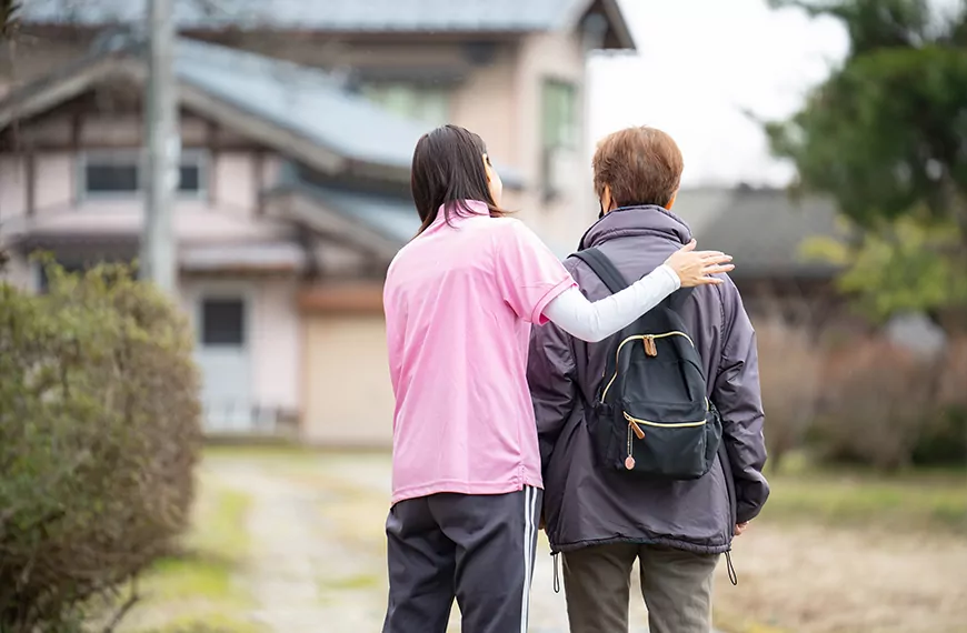 Avustaja ja asiakas kodin edessä